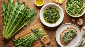 Cicoria catalogna fresca e cotta in diversi piatti su tavolo di legno, con olio, limone e aglio