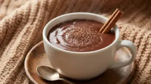 Tazza di cioccolata calda cremosa con cannella su piattino in legno