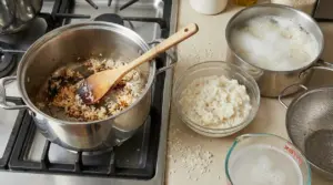 Pentola con riso bruciato sul fornello, riso scotto in ciotola e acqua schiumosa da risciacquo sul piano cucina