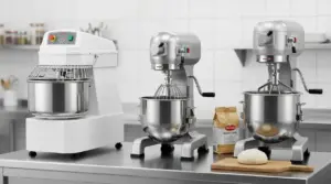 Impastatrici professionali da cucina su un banco: una a spirale e due planetarie con ciotola in acciaio