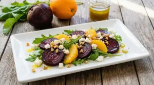 Insalata con barbabietola, arancia, rucola, formaggio e noci su piatto bianco