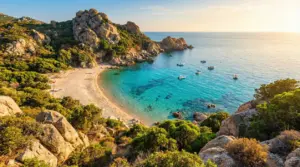 Spiaggia sabbiosa con mare turchese circondata da rocce e vegetazione mediterranea