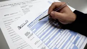 Una mano compila un modulo dell'Agenzia delle Entrate su un tavolo.