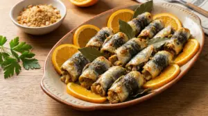 Piatto di sarde a beccafico alla siciliana con fette d'arancia e foglie di alloro