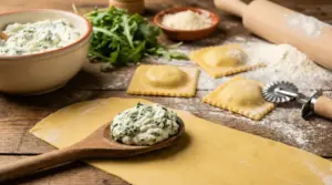 Ripieno cremoso per ravioli fatti in casa su sfoglia fresca con ravioli già chiusi e ingredienti sul tavolo
