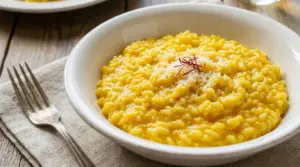 Piatto di risotto alla milanese con zafferano, servito con parmigiano grattugiato
