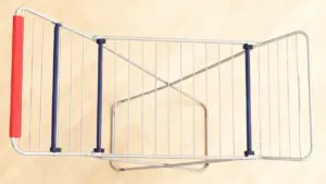 Stendibiancheria pieghevole in metallo visto dall'alto su pavimento chiaro