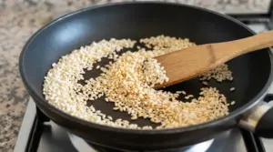 Riso per risotto tostato a secco in padella antiaderente con cucchiaio di legno sul fornello
