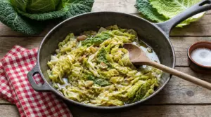 Verza stufata in padella con olio, aglio e legumi su tavolo rustico